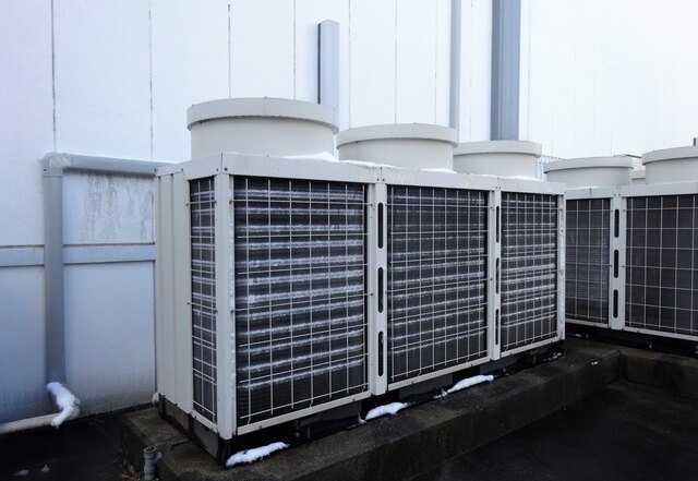 工場に設置された設備用エアコンの大型室外機と配管